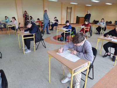 Uczestnicy konkursu Bezpieczeństwo w Ruchu Drogowym siedzą w ławkach, piszą