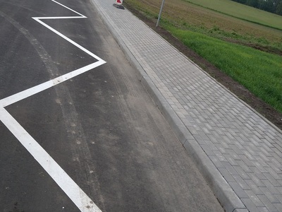 Otwarcie drogi gminnej w miejscowości Płochocin, zdjęcie drogi i przystanek autobusowy