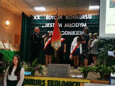 XX. Konkurs ekologiczny w SP Lipinki, dzieci na tle napisu XX Edycja konkursu Jestem Młodym Przyrodnikiem