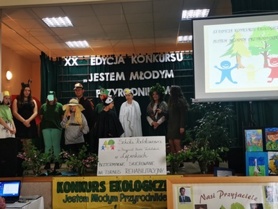 XX. Konkurs ekologiczny w SP Lipinki, dzieci na tle napisu XX Edycja konkursu Jestem Młodym Przyrodnikiem