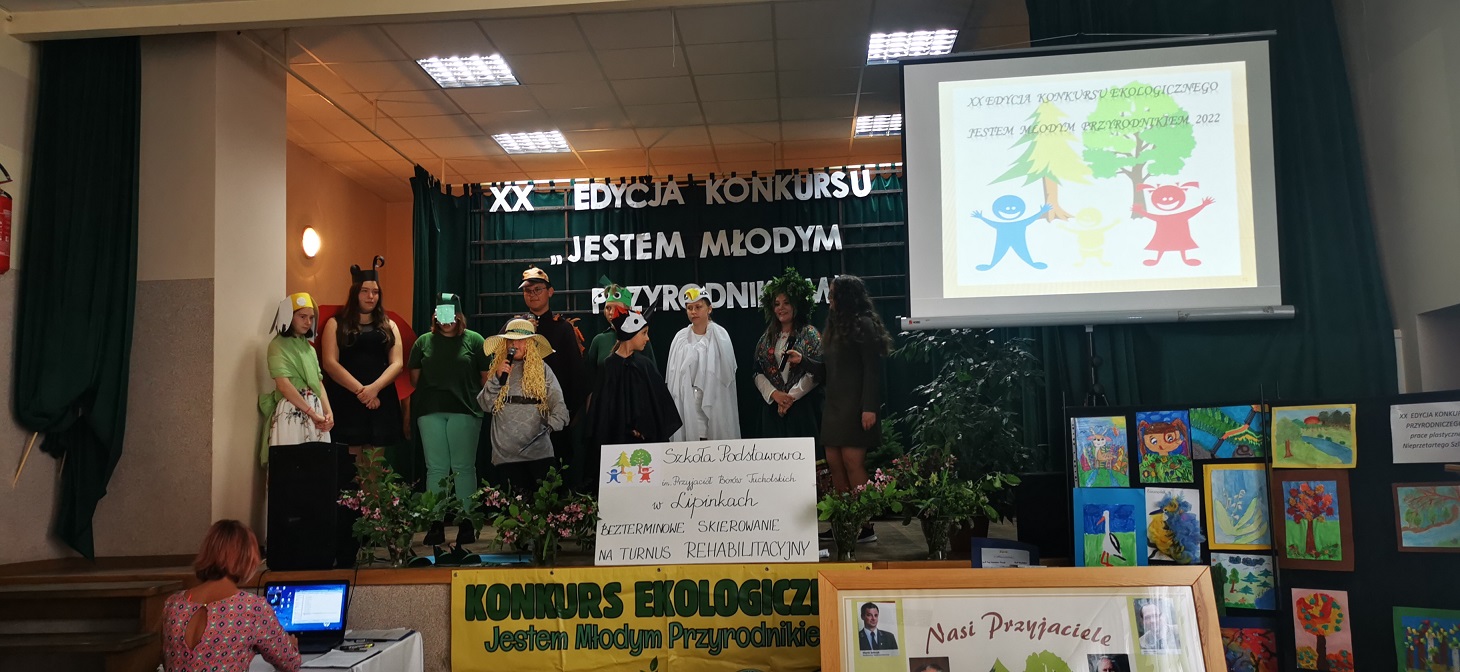 XX. Konkurs ekologiczny w SP Lipinki, dzieci na tle napisu XX Edycja konkursu Jestem Młodym Przyrodnikiem