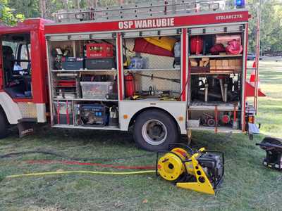 Ćwiczenia OSP, wóz strażacki widok z boku, otwarte klapy, widoczne szczegółowe wyposażenie wozu