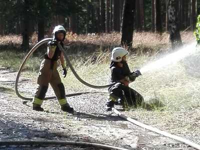 Ćwiczenia OSP, dwóch strażaków trzyma wąż strażacki