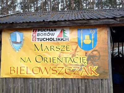 Baner Marszów na Orientację "Bielowszczak" w Borach Tucholskich na drewnianej wiacie, z herbami i logotypem wydarzenia