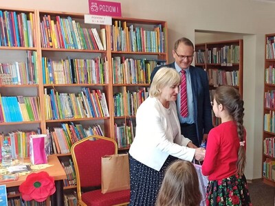 podsumowanie konkursu "Pożeracze książek", Przewodnicząca Rady Gminy wręcza dziecku upominek