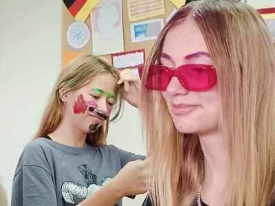 Dzień Fryzjera. Dziewczyny w zabawnym makijażu i stylizacjach w klasie z dekoracjami