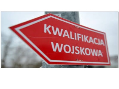 Czerwony znak drogowskazowy z napisem 'KWALIFIKACJA WOJSKOWA', wskazujący kierunek.