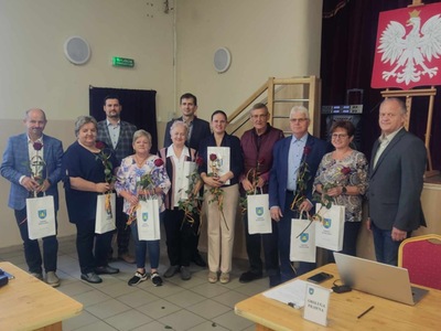 Pożegnanie sołtysów. Wójt, Przewodniczący, Sołtysi z różami i torbami z herbem gminy Warlubie podczas uroczystości w sali OSP