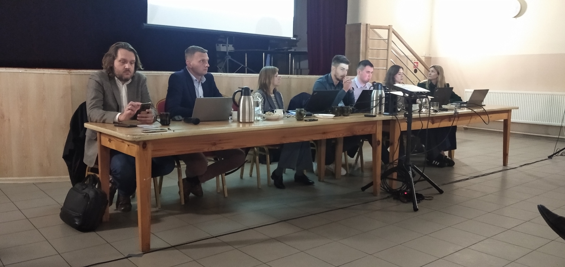 Spotkanie z mieszkańcami w sprawie budowy linii kolejowych CPK, przedstawiciele CPK siedzą przy stole