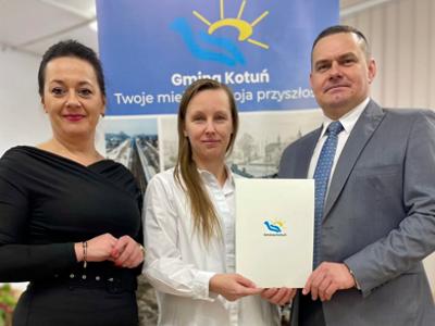 Pani Marzena Paczuska, nauczyciel Zespołu Oświatowego w Kotuniu w otoczeniu Wójta i Sekretarz Gminy Kotuń