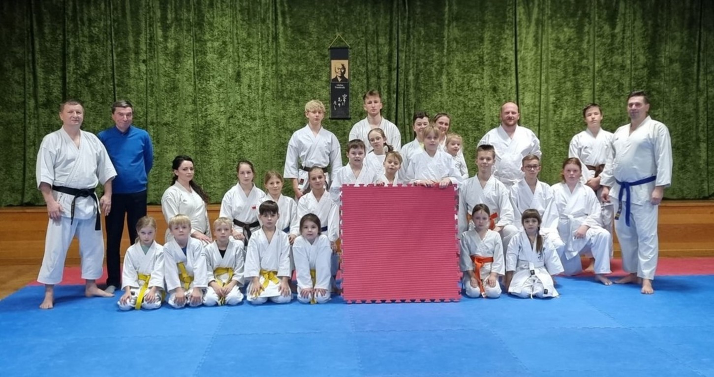 Od lewej: Instruktor Marek Szyca, wójt gminy Karsin Roman Brunke oraz zawodnicy karsińskiego Klubu Karate „Inazuma” na nowej macie treningowej.