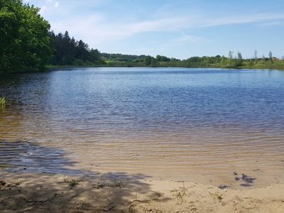 Zdjęcie przedstawia Jezioro w Pękaninie i plażę piaskową. 