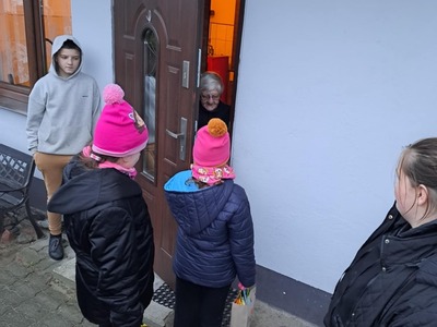 Dzieci wręczają prezenty seniorom