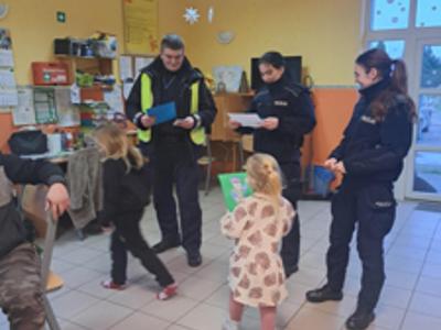 Dzieci wręczają laurki policjantom.