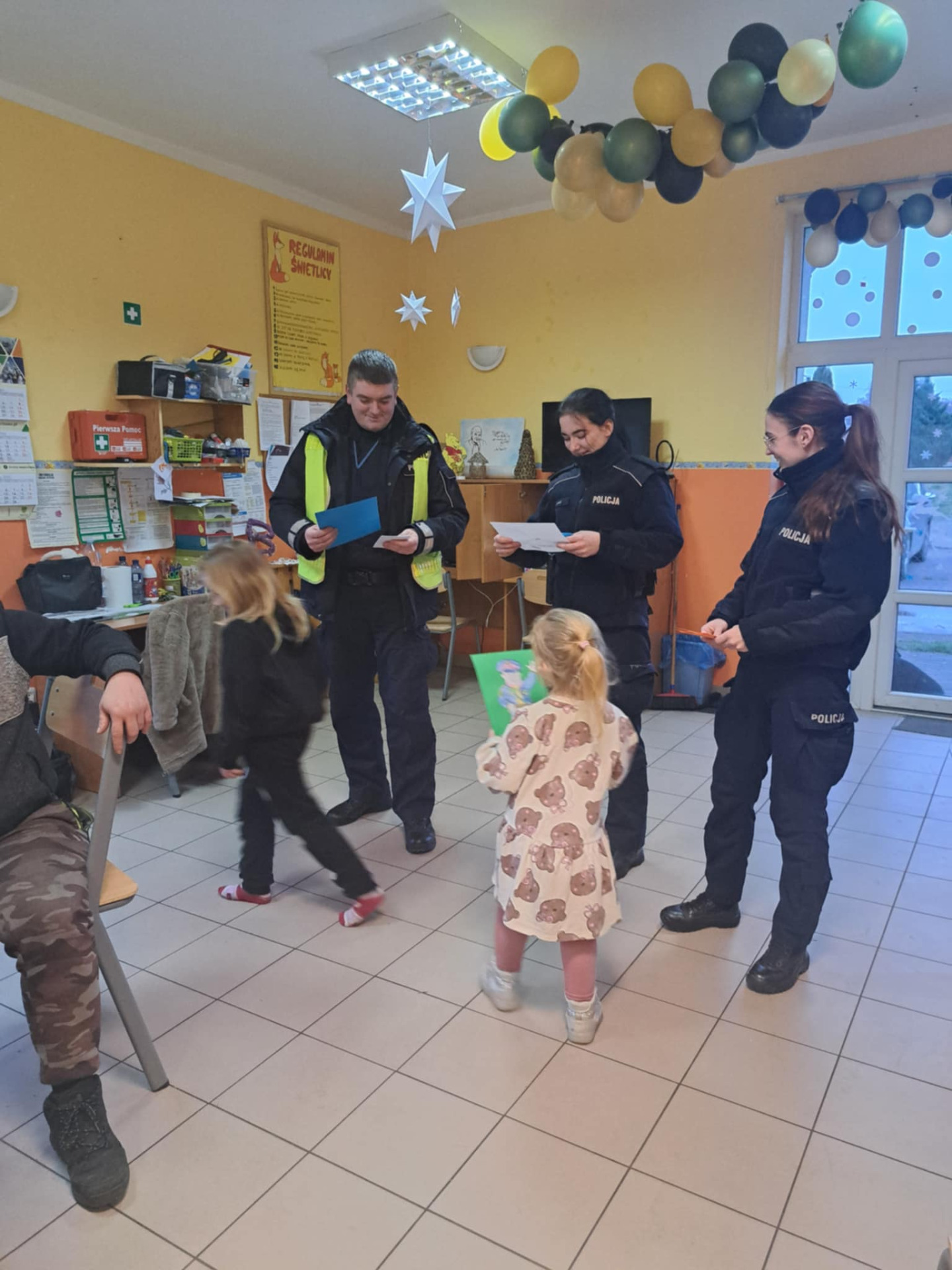 Dzieci wręczają laurki policjantom. 