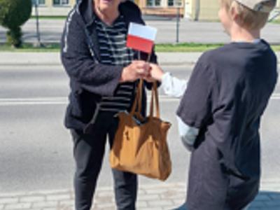 Dzieci rozdaja flagi w Ostrowcu