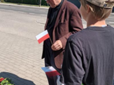 Dzieci rozdaja flagi w Ostrowcu