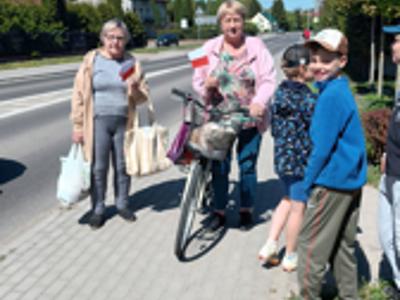 Dzieci rozdaja flagi w Ostrowcu