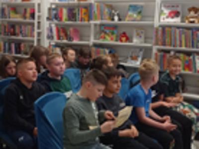 Uczniowie kl. III w trakcie słuchania bibliotekarza opowiadającego o historii książki