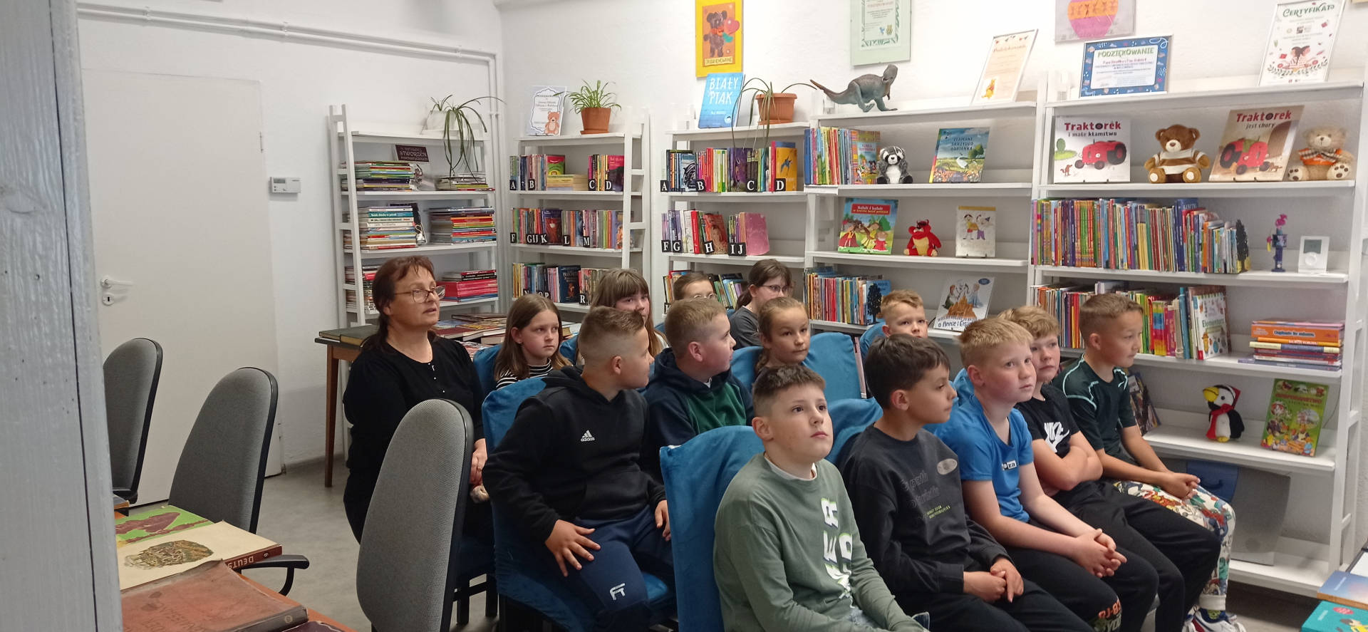 Uczniowie kl. III w trakcie słuchania bibliotekarza opowiadającego o historii książki