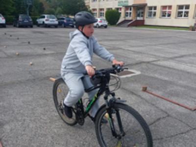 Uczeń klasy IV jeżdżący na rowerze podczas zajęć praktycznych na kartę rowerową.
