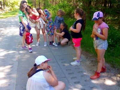 Zdjęcie przedstawia odpoczynek dzieci z Placówki Wsparcia Dziennego w Laskach w lesie.