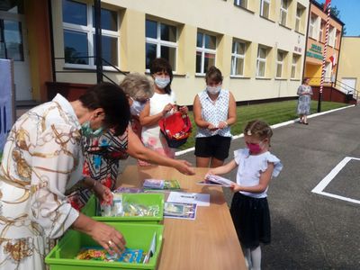 Zdjęcie przedstawia przedszkolaka i grono pedagogiczne ZS Ostrowiec podczas zakończenia roku szkolnego. 