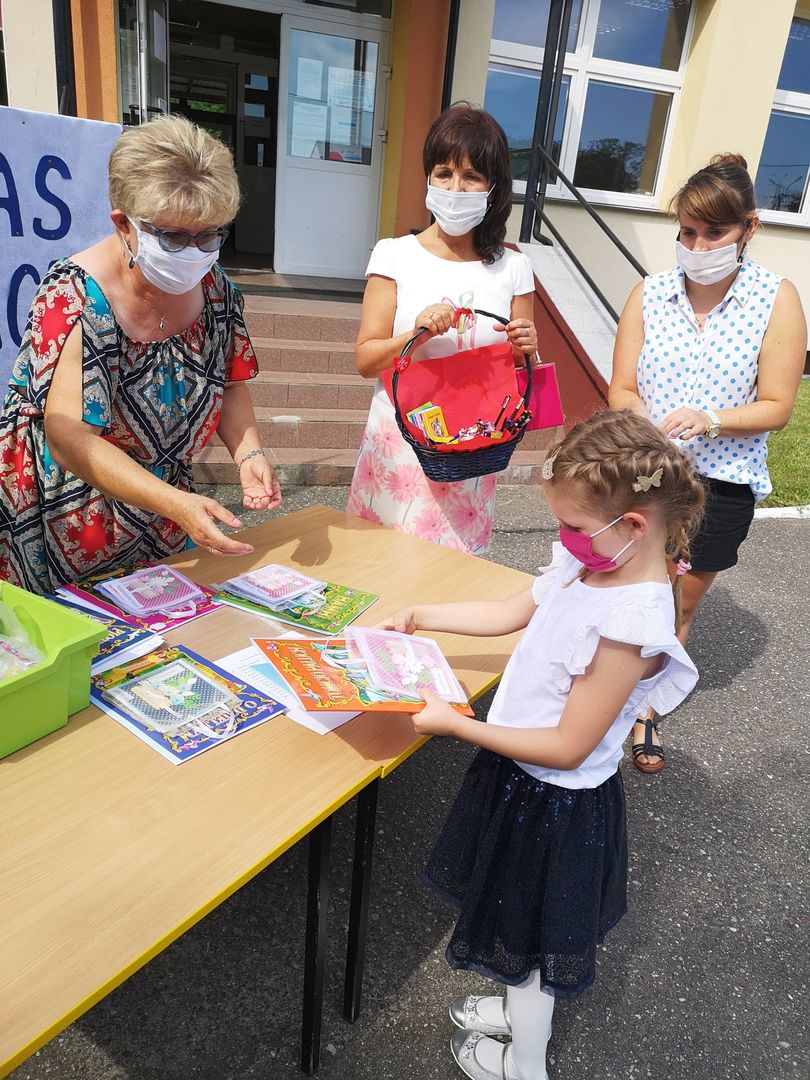 Zdjęcie przedstawia przedszkolaka i grono pedagogiczne ZS Ostrowiec podczas zakończenia roku szkolnego.