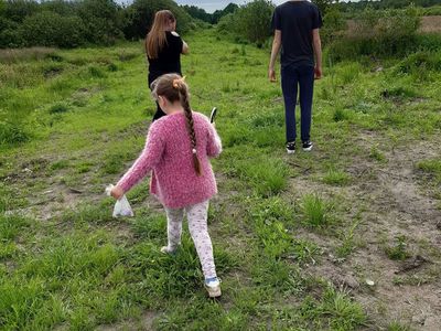 Zdjęcie przedstawia wychowanków Placówki Wsparcia Dziennego w Paprotach podczas zajęć przyrodniczych na świeżym powietrzu.