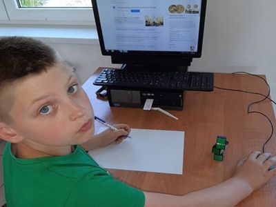 Zdjęcie przedstawia wychowanka Placówki Wsparcia Dziennego w Przystawach przy komputerze. 
