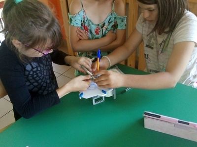 Zdjęcie przedstawia dzieci z Lasek podczas zajęć z robotyki. 