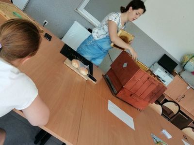 Zdjęcie przedstawia wychowawcę Placówki Wsparcia Dziennego i dziewczynkę podczas zajęć matematyczno-przyrodniczych.