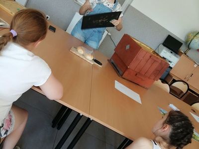 Zdjęcie przedstawia wychowawcę i wychowanków Placówki Wsparcia Dziennego w Kusicach podczas zajęć matematyczno-przyrodniczych.