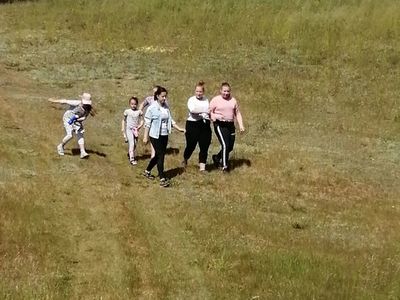 Zdjęcie przedstawia wychowawcę i wychowanków Placówki Wsparcia Dziennego w Kusicach na spacerze podczas zajęć matematyczno-przyrodniczych.