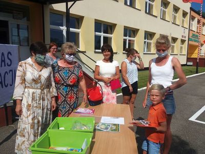 Zdjęcie przedstawia dyrektor placówki i wychowawczynie z przedszkola w Ostrowcu, chłopca z opiekunką odbierającego pamiątkowe dyplomy. 