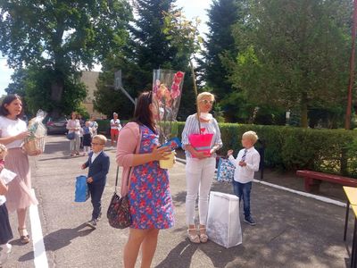 Zdjęcie przedstawia rodziców i dzieci z kwiatami. 