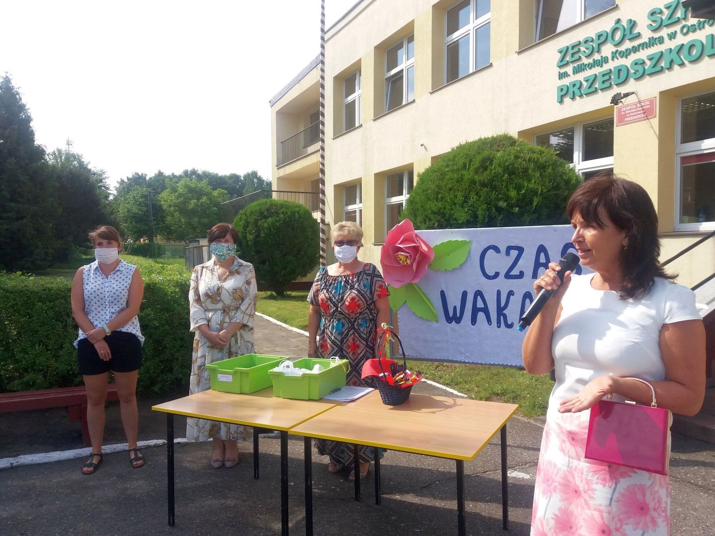 Zdjęcie przedstawia przemawiająca dyrektor Barbarę Chylewską i wychowawczynie z przedszkola w tle. 