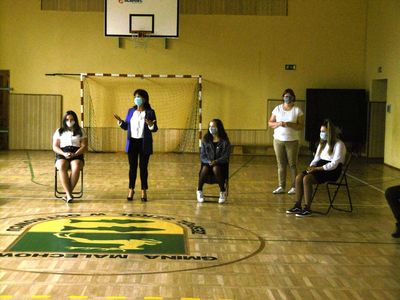 
Zdjęcie przedstawia dyrektor i uczniów w sali gimnastycznej. 
