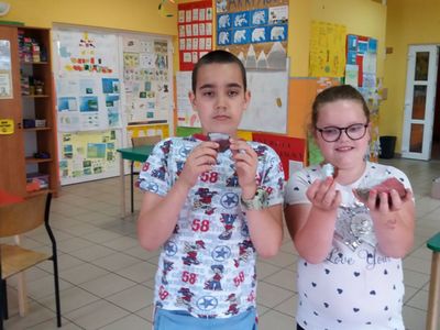Zdjęcie ukazuje wychowanków Placówki Wsparcia Dziennego w Laskach z wykonanymi przez nich kamieniami.