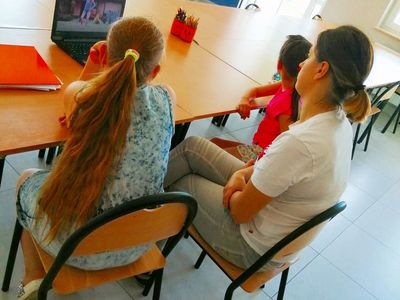 Zdjęcie przedstawia dzieci z Kusic wraz z wychowawczynią podczas zajęć dziennikarsko - teatralnych.