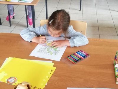 Zdjęcie przedstawia wychowankę Placówki Wsparcia Dziennego w Sulechowie kolorującą obrazek. 