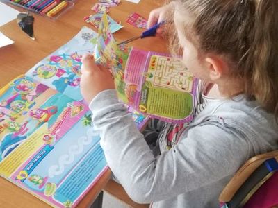 Zdjęcie przedstawia dziewczynkę z Placówki Wsparcia Dziennego z Sulechowa wykonującą pracę plastyczną. 