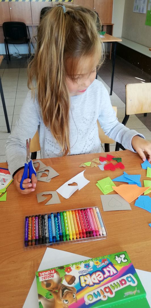 Zdjęcie przedstawia dziewczynkę z Placówki Wsparcia Dziennego z Sulechowa wykonującą pracę plastyczną. 