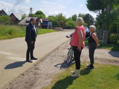 Zdjęcie przedstawia wójta Radosława Nowakowskiego podczas rozmowy z mieszkańcami Bartolina i sołtys Katarzyną Kozioł.