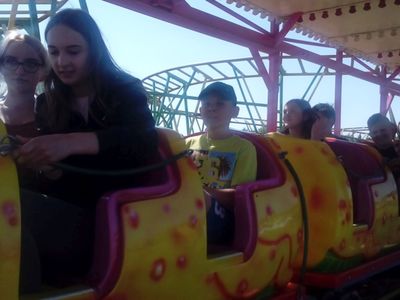 Zdjęcie przedstawia wychowanków Placówki Wsparcia Dziennego z Ostrowca przygotowanych do jazdy kolejką w parku Pomerania. 
