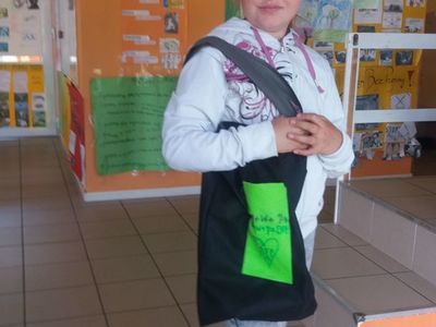 Zdjęcie przedstawia wychowankę Placówki Wsparcia Dziennego w Laskach z własnoręcznie uszytą torbą.