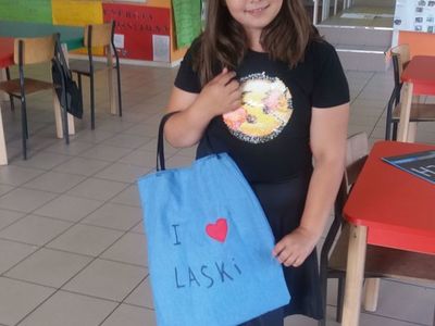 Zdjęcie przedstawia wychowankę Placówki Wsparcia Dziennego w Laskach z własnoręcznie uszytą torbą. 