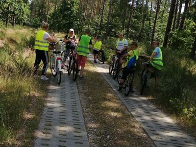 Zdjęcie przedstawia dzieci z Placówki Wsparcia Dziennego w Kusicach wraz z opiekunami podczas rajdu rowerowego do Sierakowa, 