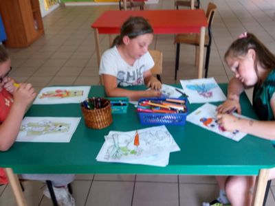 Zdjęcie przedstawia wychowanki Placówki Wsparcia Dziennego w Laskach wykonujących prace plastyczne. 
