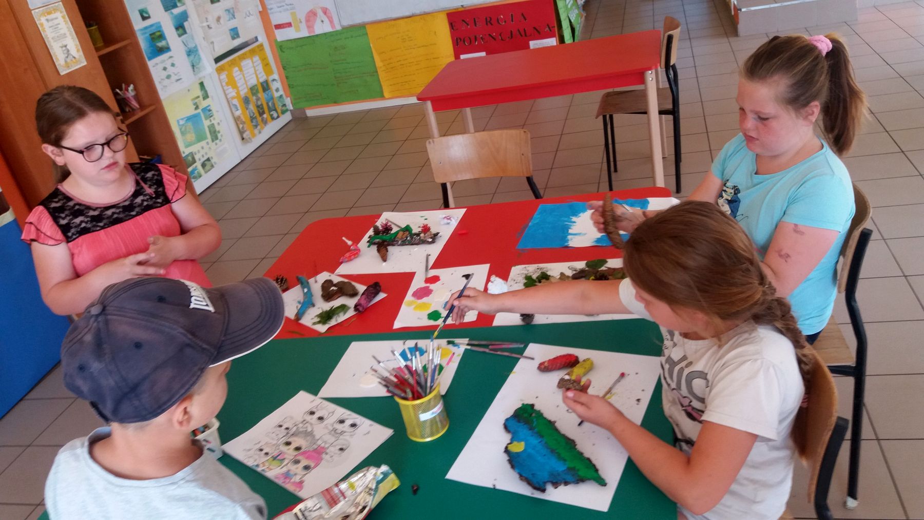 Zdjęcie przedstawia wychowanków Placówki Wsparcia Dziennego w Laskach wykonujących prace plastyczne.